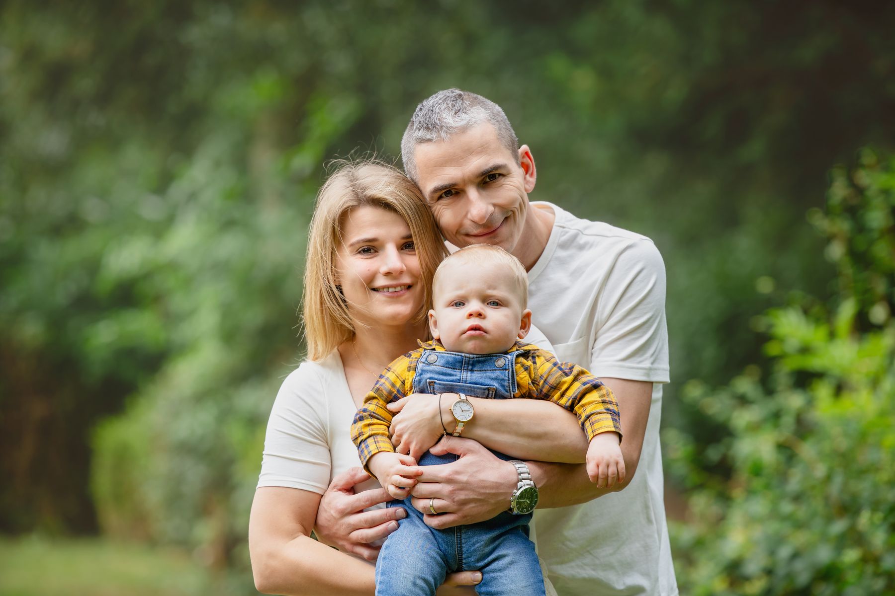 Smiling parents holding their baby outdoors